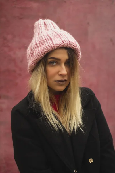 Chica rubia con los ojos grandes y rellenar los labios sobre un fondo rosa. mujer en voluminoso sombrero de polvo de color cálido . —  Fotos de Stock