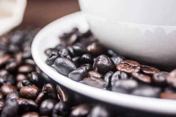 Makro kahve çekirdeği üzerinde beyaz tabak.