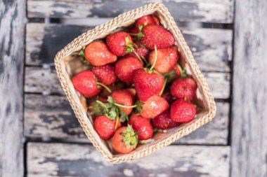 Taze çilek sepeti ahşap arka plan üzerinde.