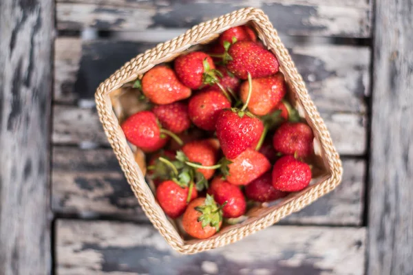 Taze çilek sepeti ahşap arka plan üzerinde.