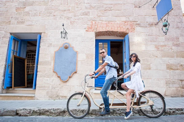 Young couple on tandem bicycle at the street city — Stock Photo, Image