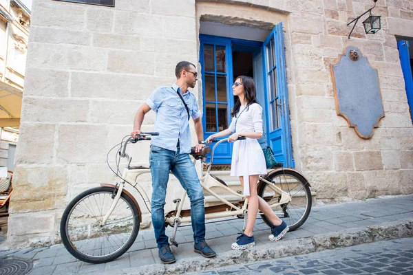 Pareja joven en bicicleta tándem en la ciudad de la calle — Foto de Stock