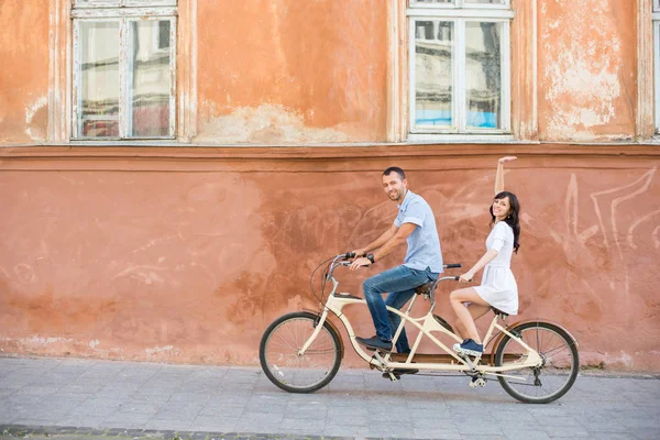 街市でタンデム自転車に若いカップルします。 — ストック写真