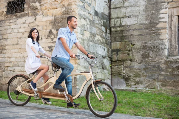 Jeune couple en tandem rétro à la ville de la rue — Photo