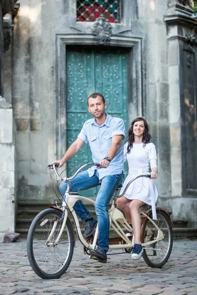 Young couple on retro tandem bicycle at the street city — Stock Photo, Image