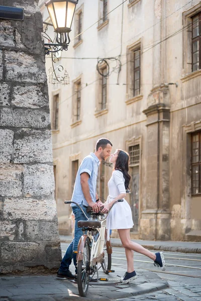 Νεαρό ζευγάρι με ρετρό ποδήλατο παράλληλα στο δρόμο πόλης — Φωτογραφία Αρχείου