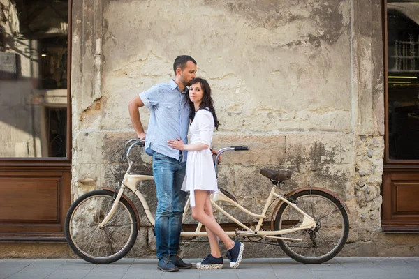 Молодая пара с ретро тандемом велосипед на улице города — стоковое фото