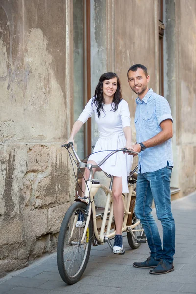 Young couple on retro tandem bicycle at the street city — Stock Photo, Image