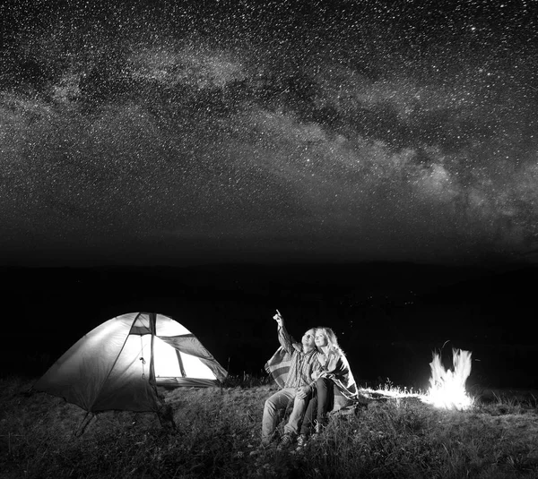 Turist man visar rödhårig kvinna på stjärnorna på himlen. — Stockfoto