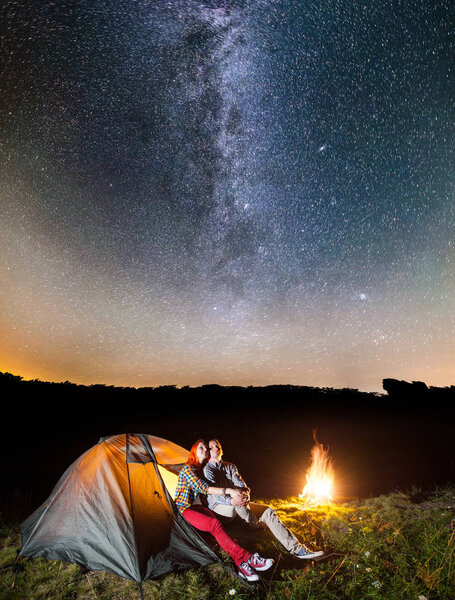 Happy couple tourists looking to the shines starry sky