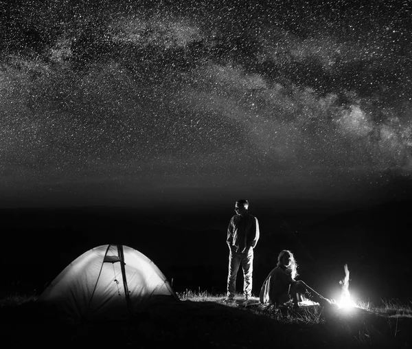 Touristes couples romantiques dans son camp la nuit près du feu de camp — Photo