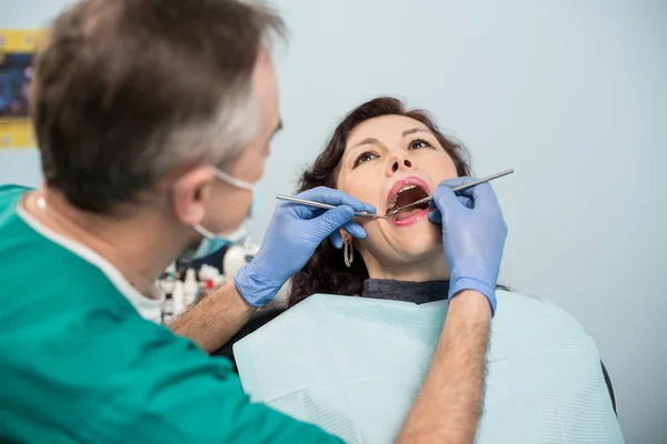 Frau lässt sich beim Zahnarzt untersuchen — Stockfoto