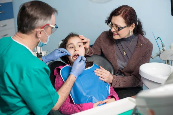 Junges Mädchen mit ihrer Mutter beim ersten Zahnarztbesuch. — Stockfoto