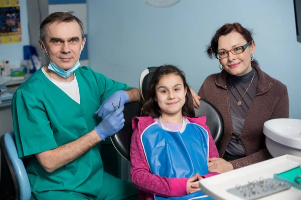 Retrato del dentista pediátrico senior y la niña con su madre en la primera visita dental en el consultorio dental. Odontología, medicina, estomatología y cuidado de la salud. Equipos dentales — Foto de Stock