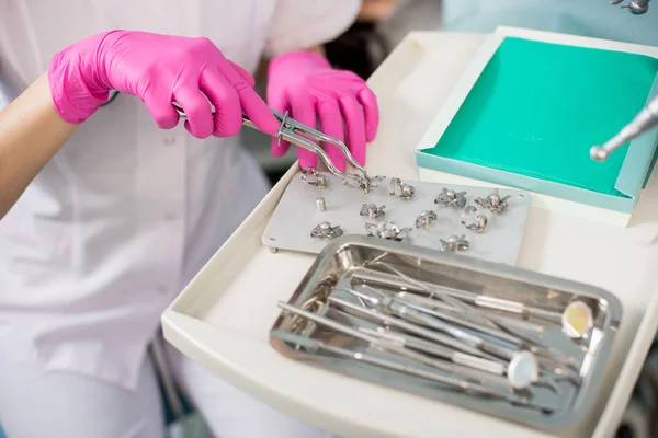 Zahnarzt mit behandschuhten Händen arbeitet mit zahnärztlichen Geräten — Stockfoto