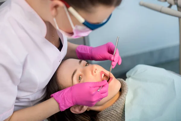 Dentiste féminine traitant les dents des patients — Photo