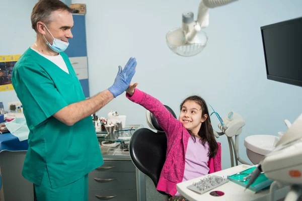 Dentista pediátrico sênior e menina feliz — Fotografia de Stock