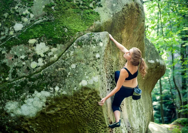 Молода жінка сходження на великі валуни на відкритому повітрі — стокове фото