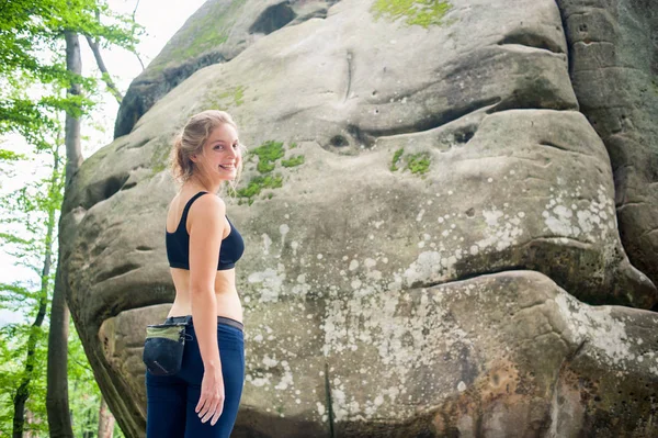 Mujer joven con equipo de escalada delante de una piedra — Foto de Stock