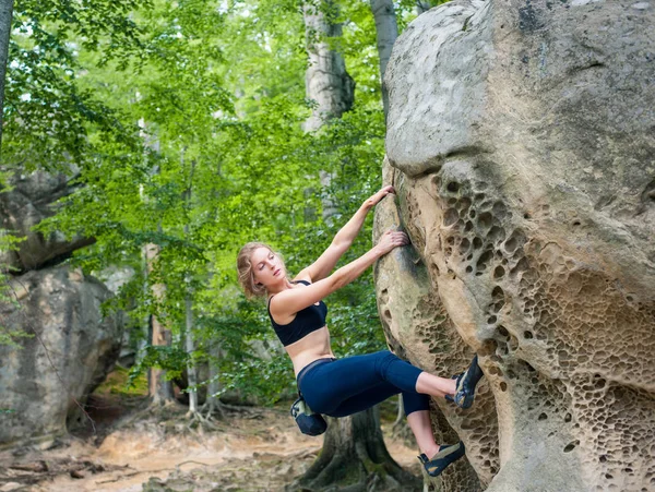 Young woman climbing on large boulders outdoor — Stock Photo, Image