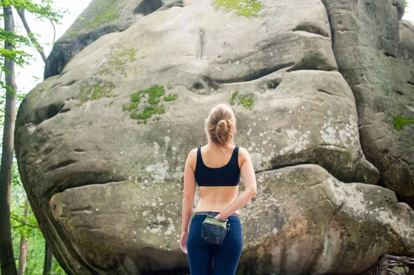 Młoda kobieta z wspinaczki sprzętu przed kamieniem — Zdjęcie stockowe
