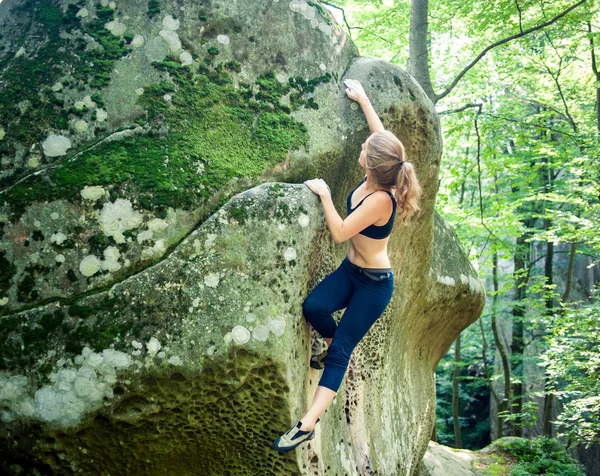 Jovem mulher escalando em grandes pedras ao ar livre — Fotografia de Stock