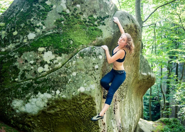 Jovem mulher escalando em grandes pedras ao ar livre — Fotografia de Stock