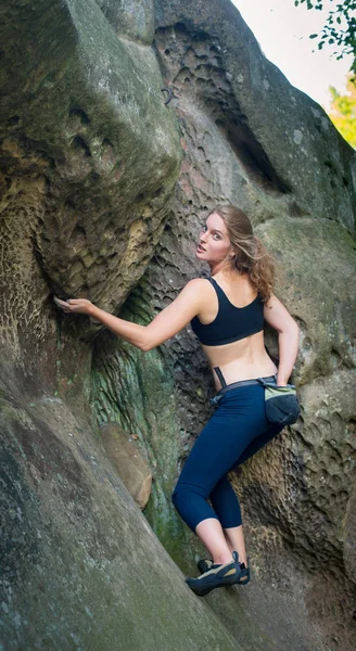 Mujer joven escalando en grandes rocas al aire libre — Foto de Stock