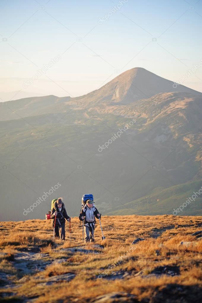 Couple hikers in the Carpathians mountains with backpacks