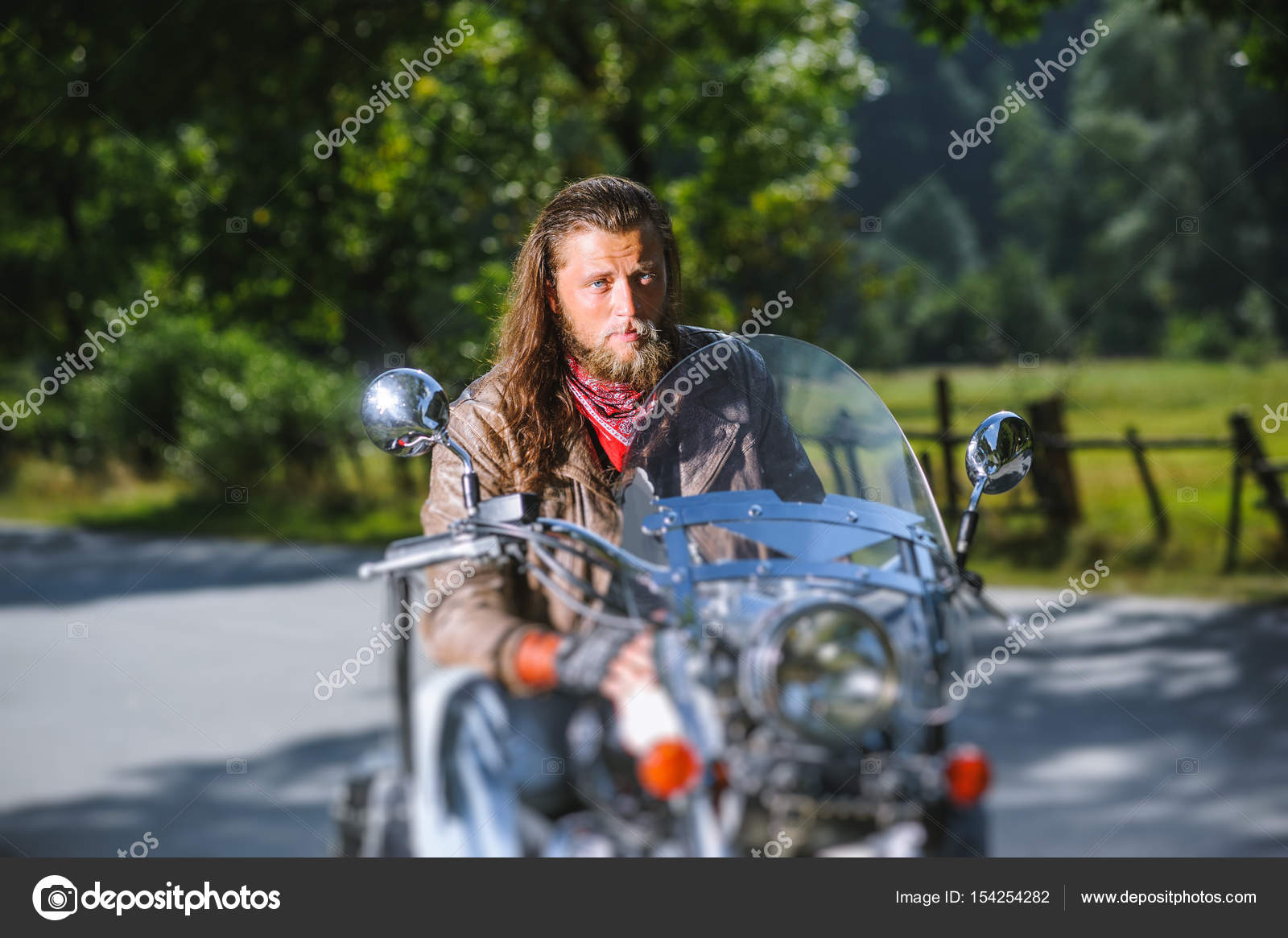 Portrait of biker man with beard sitting on his motorcycle Stock Photo by  ©anatoliy_gleb 154254282
