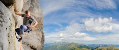 Erkek ip ile doğada büyük kaya tırmanma tırmanıcı