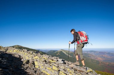 Adam backpacker dağın kayalık sırtta yürüyüş