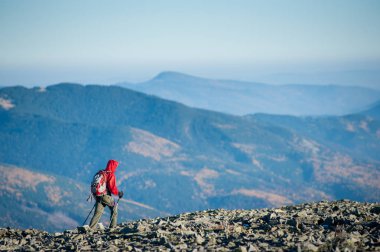 Erkek backpaker dağın kayalık zirvesine yürüyüş