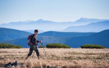 Erkek backpacker trekking sopalarla yürüyüş