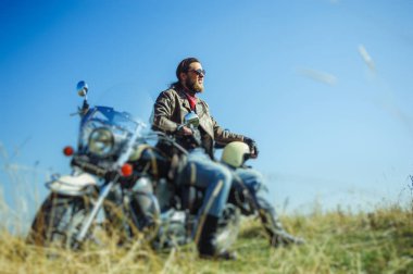 Güneşli bir günde onun motosiklet üzerinde oturan vahşi motorcu