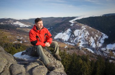 Rock dağın tepesinde oturan erkek turist
