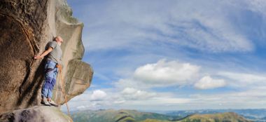 Erkek ip ile doğada büyük kaya tırmanma tırmanıcı