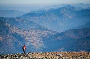 Erkek backpaker dağın kayalık zirvesine yürüyüş
