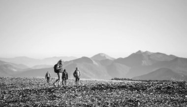 Dört genç atletik insanlar üzerinde kayalık dağ yürüyüş plato
