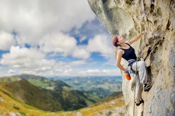 Vrouwelijke rock klimmer op steile overhangende rots rots — Stockfoto