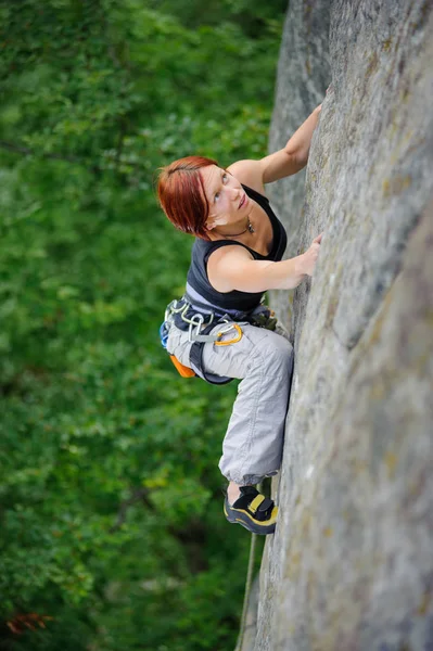 Athletic woman climbing steep cliff wall in summer time — Stock Photo, Image