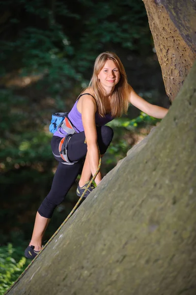 岩の壁にロープで登る女性登山家 — ストック写真