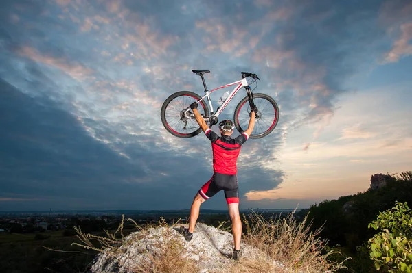 Ciclista elevando la bicicleta de montaña por encima de su cabeza con éxito —  Fotos de Stock