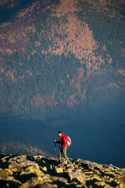 Backpaker masculino andando no topo rochoso da montanha — Fotografia de Stock