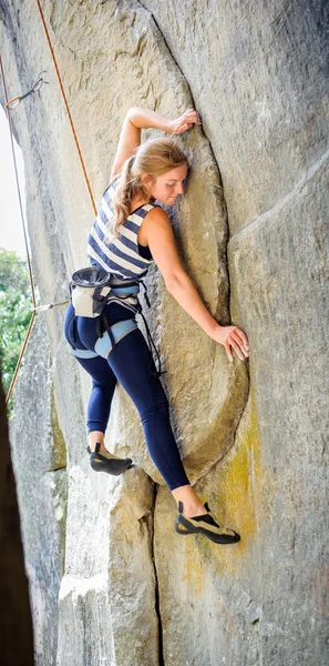 Female climber climbing with rope on a rocky wall — Stock Photo, Image