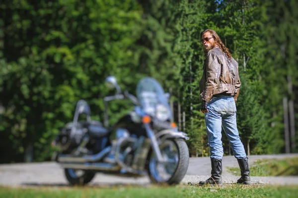 Motociclista em pé por sua motocicleta cruzador feito sob encomenda — Fotografia de Stock