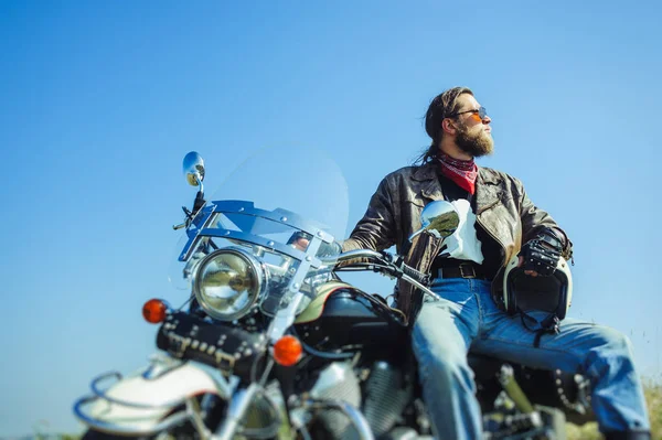 Жестокий байкер сидит на мотоцикле в солнечный день — стоковое фото