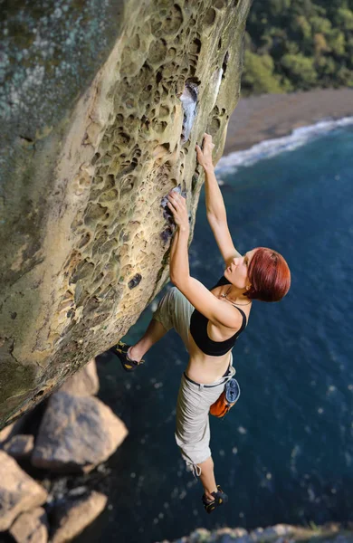 Vrouwelijke klimmer klimmen zonder touw op een rotsachtige wand — Stockfoto