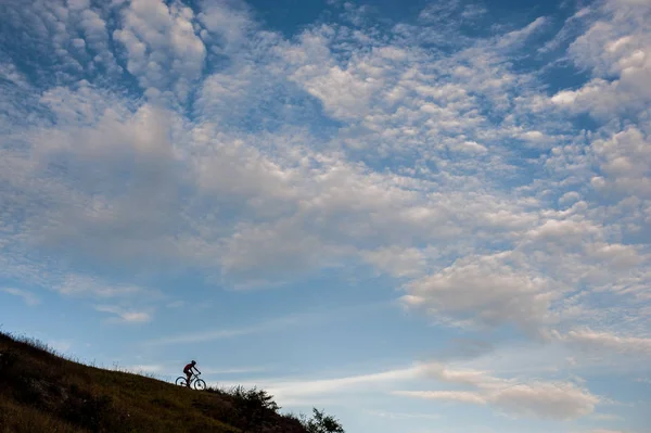 Silhouette of a cross country cyclist going downhill — Stock Photo, Image