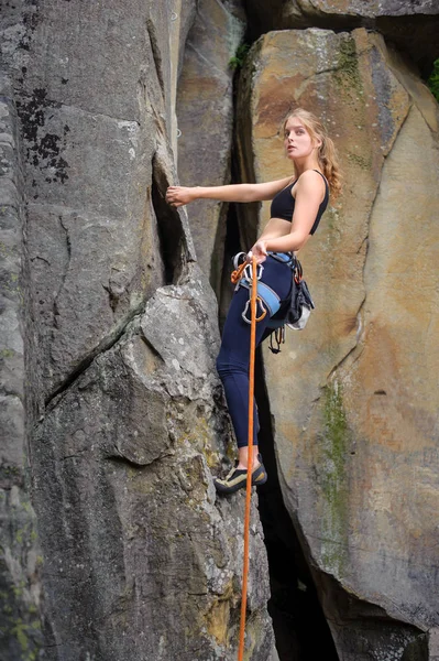 Female climber climbing with rope on a rocky wall — Stock Photo, Image